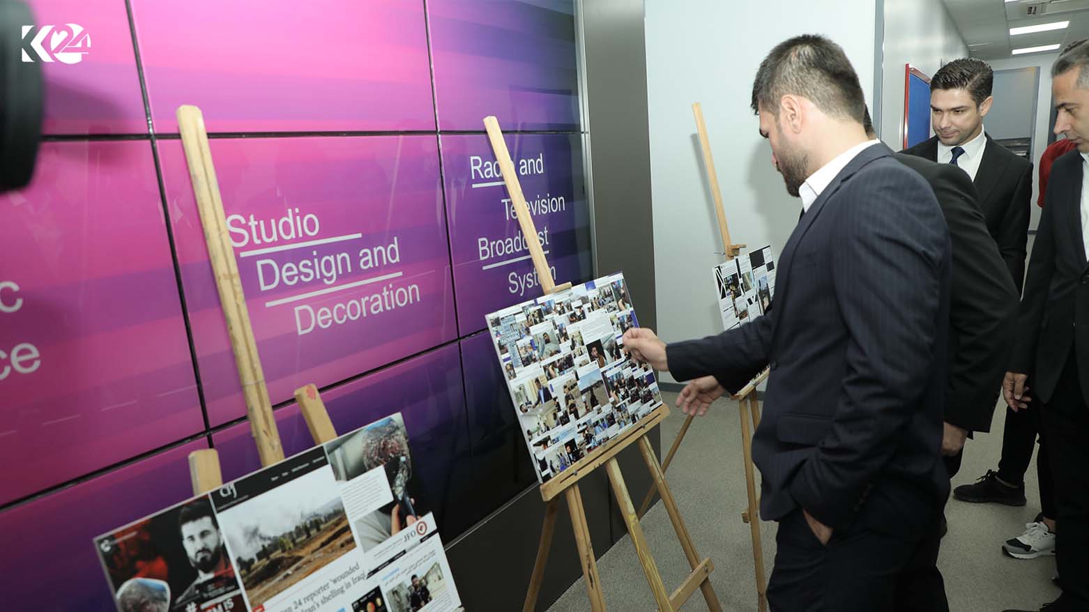 Kurdistan 24 Kirkuk reporter (center) displays screengrabs of media reports conducted on the Iranian attacks in Sept. 2022 in which he was seriously wounded at an exhibition in Erbil, Sept. 28, 2023. (Photo: Kurdistan 24)