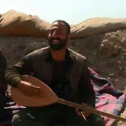 Abu Layla plays on a Kurdish mussical instrument (Buzuq) in a warrior rest, northern Syria, 2015. (Photo: Mustafa Ebdi blog in Arabic)