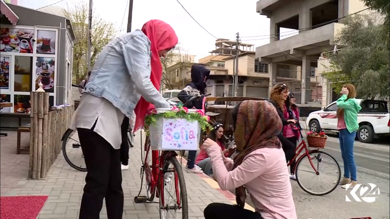 Kurdish women voluntarily deliver books on bikes