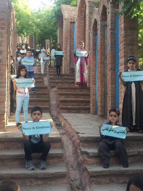 Children in Sardasht mark the tragedy that affects their lives to this day by holding placards that read Peace and Kindess in three languages, Kurdish, English and Farsi. (Photo: Facebook)