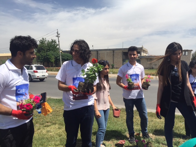 A group of volunteers planting flowers in one of the streets of Erbil.