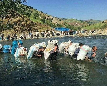 کولبران ناچار هستند هنگام حمل بارهای سنگین از رودخانە عبور کنند