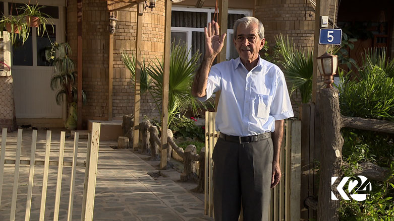 Kurdish writer Mumtaz Haidari standing in front of his house fairwelling Kurdisatn24 crew in Erbil, Kurdistan Region, July 2, 2017. (Photo: Kurdistan24)