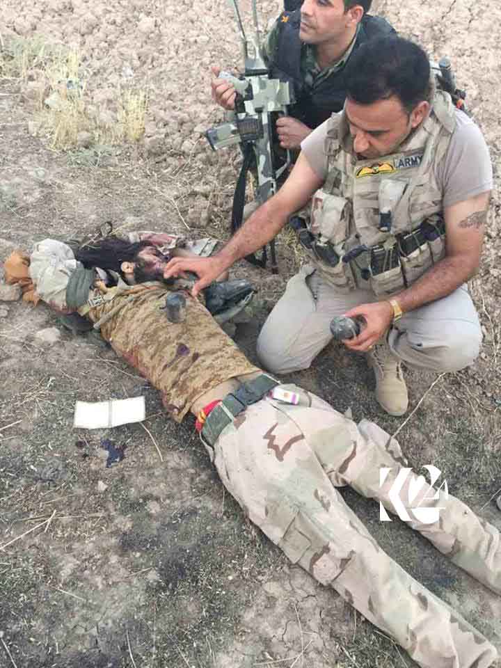 Peshmerga standing next to a dead Islamic State (IS) militant in the southwestern of Kirkuk Province, Kurdistan Region, August 16, 2017. (Photo: Kurdistan 24)