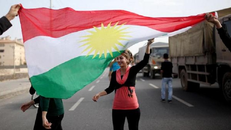 A young woman waves a Kurdistan flag as a Peshmerga convoy en route to the IS-circled town of Kobani in Syrian Kurdistan passes through the Kurdish Mardin Province, Turkey, Oct. 29, 2014. (Photo: AA)