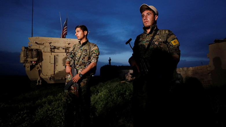Kurdish People's Protection Units (YPG) fighters stand near a US military vehicle in the town of Darbasiya, Syria, next to the Turkish border following Turkish air strikes on their position three days earlier, April 28, 2017. (Photo: Reuters)