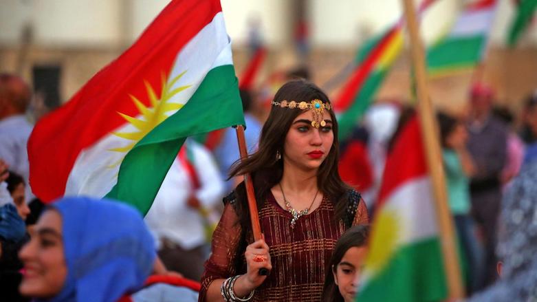 A woman holds Kurdistan flag during a rally in the Syrian Kurdish city of Qamishli in support of her kins' referendum in Kurdistan Region on independence from Iraq, Sept 26, 2017. (AFP)