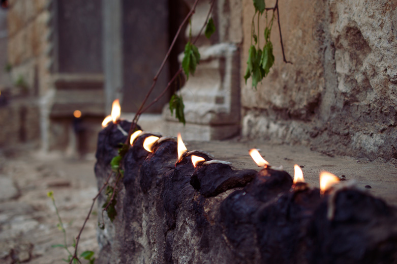 Candles lit at sunset beside the doorway