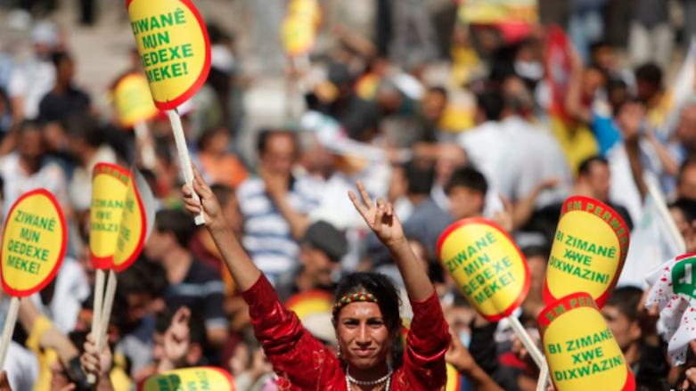 A woman holds a sign that reads 