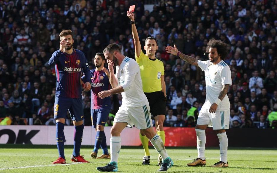 Real Madrid defender Daniel Carvajal walks off after the referee shows him a red card for a handball in the box during the second-half of the El Clasico match, Madrid, Spain, Dec. 23, 2017. (Photo: Reuters)