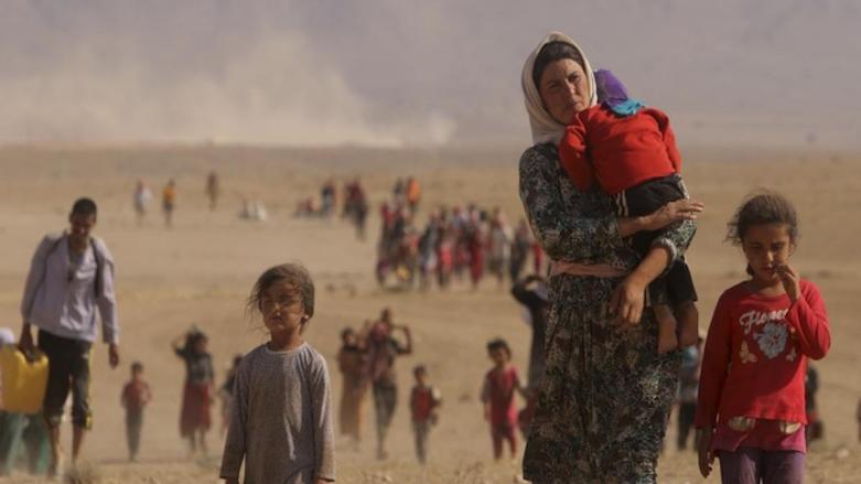 A Yezidi (Ezidi) woman carries her child as people flee to Mount Sinjar (Shingal) from the threat of the Islamic State (IS). (Photo: HRW)
