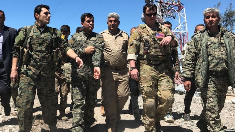 A US military commander (2nd right) walks with fighters from the Kurdish People's Protection Units (YPG) at the YPG headquarters that was hit by Turkish air strikes in Mount Qarachokh near Derika Hemo, Syrian Kurdistan, April 25, 2017. (Photo: Reuters)