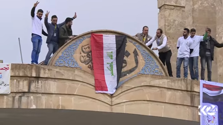 طلبة يرفعون العلم العراقي فوق جامعة الموصل