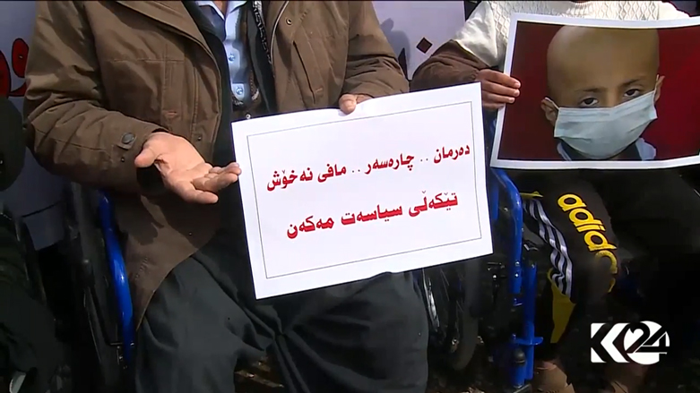 A demonstrator holds up a sign which reads: There is no solution for disease except medicine, do not confuse politics with the rights of patients. (Photo: Kurdistan 24)