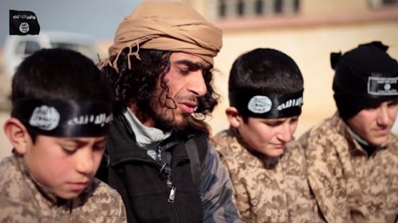 A screenshot from a propaganda video released by the Islamic State (IS) shows children wearing military uniforms being encouraged to fight within the group's ranks. 