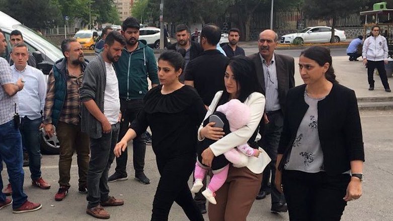 Primary school teacher Ayse Celik (center), accompanied by HDP lawmakers, carries her baby on the way to serve 15 months in jail for remarks on TV that a Turkish court deemed 'terrorist propaganda,' in the Kurdish city of Diyarbakir, April 20, 2018. (Photo: DHA)