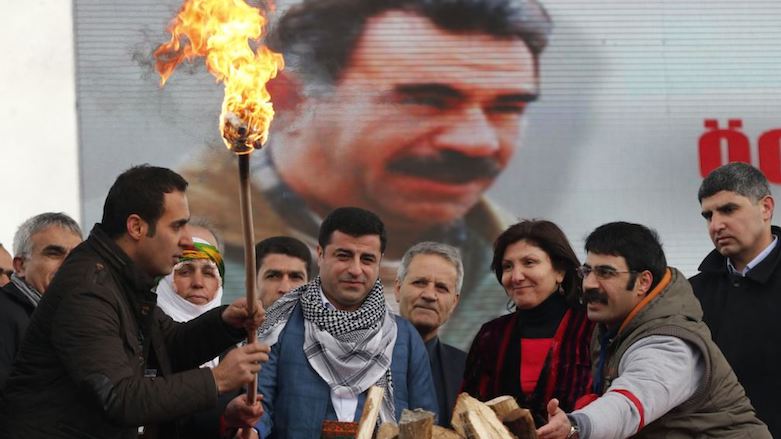 Selahattin Demirtas (center) lights fire during a celebration of spring festival of the Kurdish New Year Newroz in Istanbul, with a picture of imprisoned PKK leader Abdullah Ocalan seen on a digital screen, March 17, 2013. (Photo: Reuters)