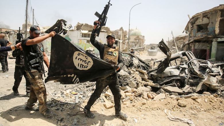 Members of the Iraqi security forces cheer as they carry an upside-down flag of the Islamic State extremist group, with the destroyed Grand Al-Nuri Mosque seen in the background, in the Old City of Mosul on July 2, 2017. (Photo: AFP)