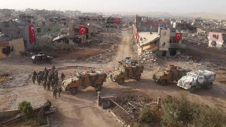 Turkish soldiers gather for a picture with their vehicles in front of demolished houses draped in Turkish flags, after months-long clashes with Kurdish rebels in the city of Nusaybin, 2016. (Photo: Archive)