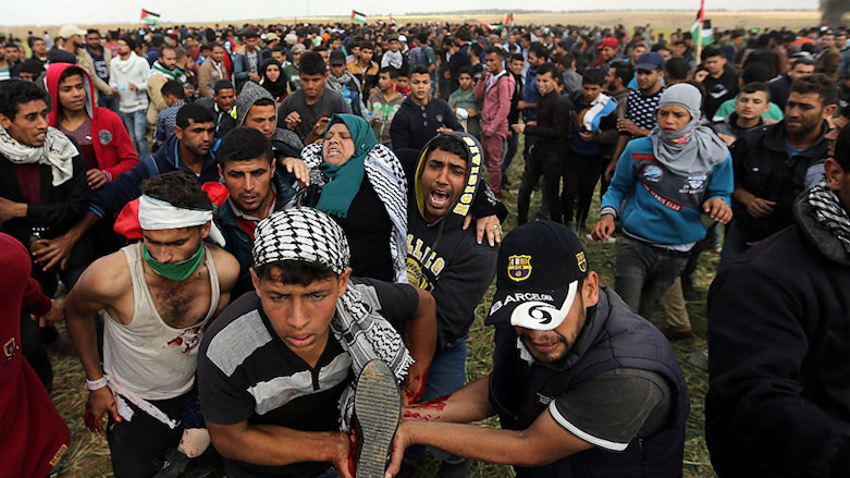 Palestinian demonstrators evacuate a woman wounded during tensions with Israeli troops at the Gaza-Israel border at a protest demanding the right to return to their homeland, in the southern Gaza Strip, March 31, 2018. (Photo: Reuters)