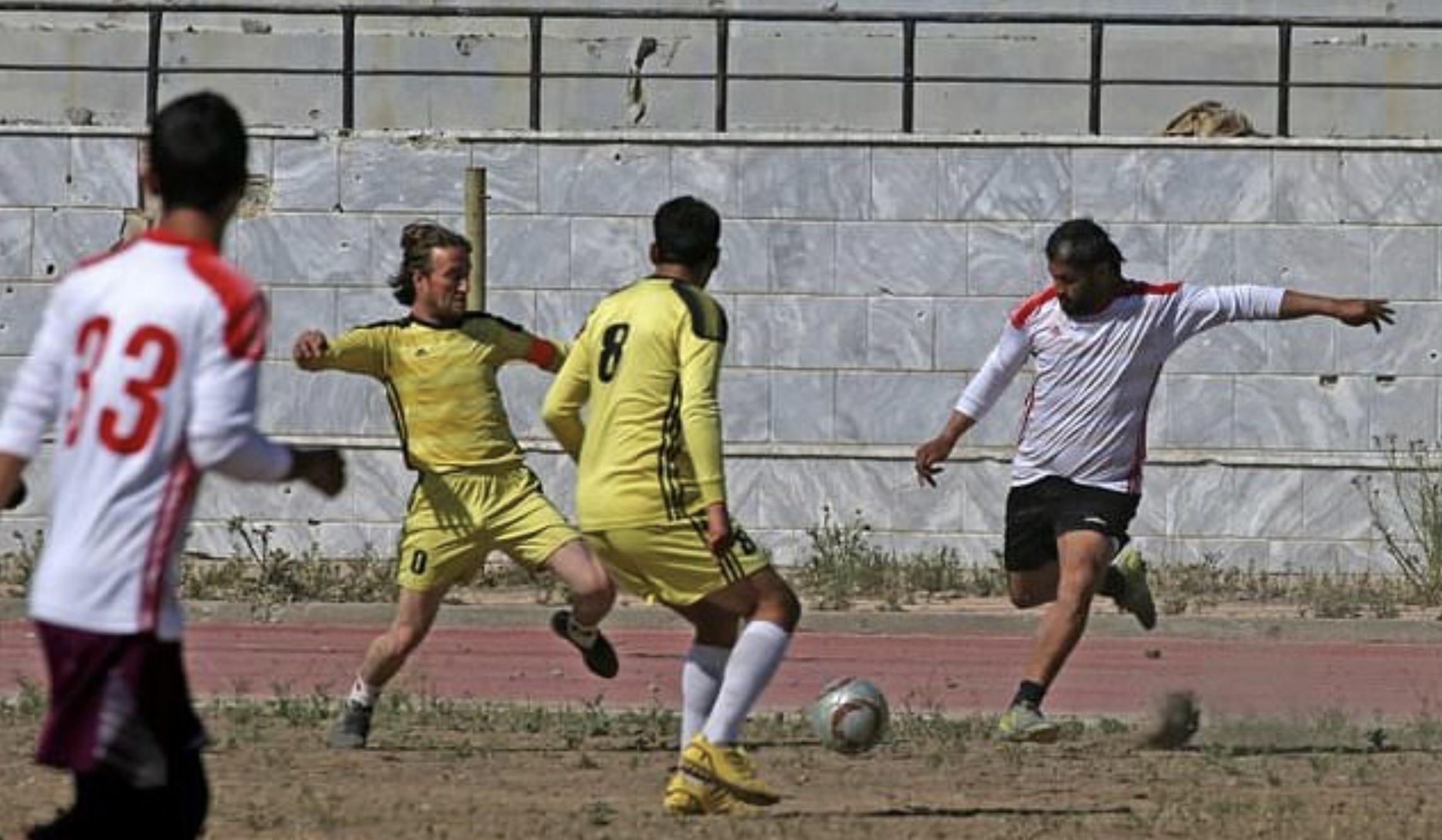 Syrians take part in a football match on April 16, 2018, between local teams at a stadium in Raqqa that the Islamic State once used as a prison. (Photo: AFP)