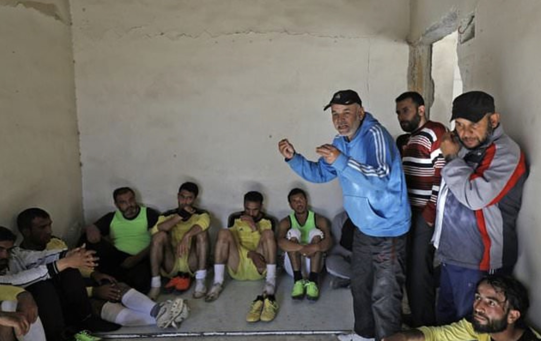 Players get a teamtalk during a football match on April 16, 2018, between local teams at a stadium in Raqqa that the Islamic State once used as a prison. (Photo: AFP)
