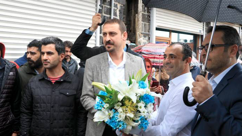 Beklevic (in a white shirt) in Diyarbakir. Head of the Kurdish city's Bar Association Ahmet Ozmen gave the Turkish activist flowers upon his arrival, May 12, 2018. (Photo: Mezopotamya Agency)