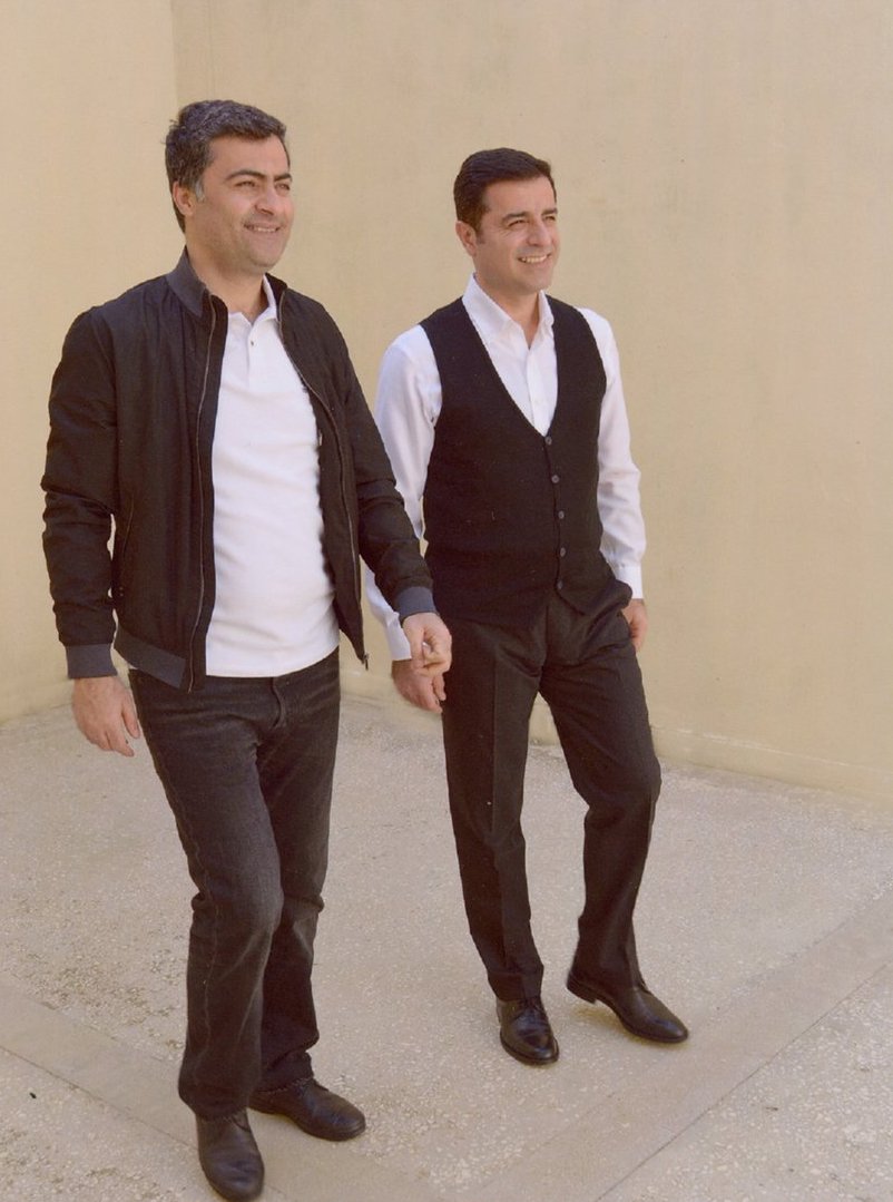 Kurdish politician and candidate for the President of Turkey, Demirtas (right), in a white shirt, black waistcoat, and trousers walking the yard in a Turkish prison with another jailed HDP lawmaker, Abdullah Zeydan. (Photo: Twitter/hdpdemirtas)