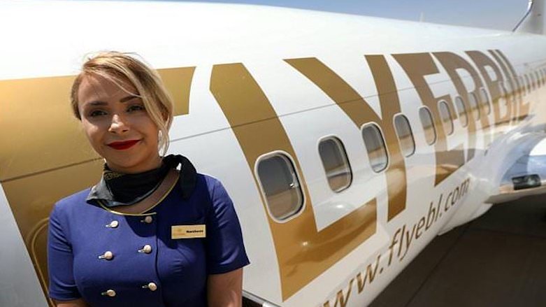A Fly Erbil airline hostess poses outside a plane scheduled to fly from Erbil International to Stockholm on June 18, 2018 (Photo: AFP)