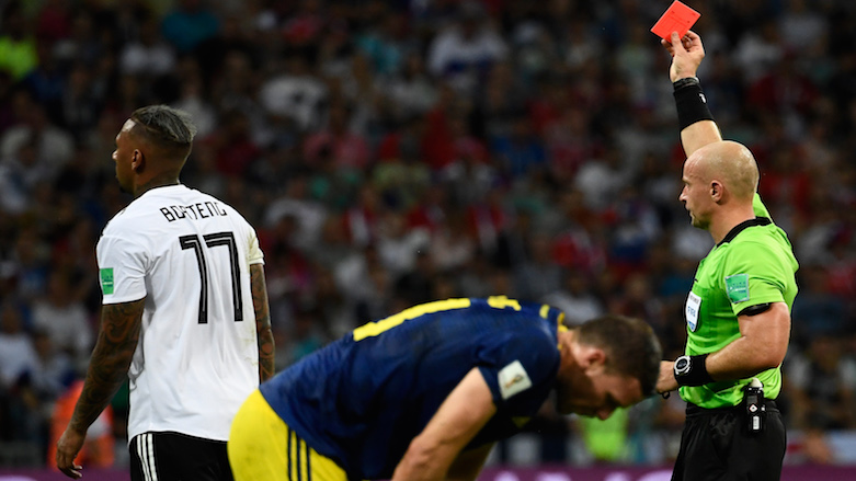 Polish referee Szymon Marciniak (right) presents Germany's defender Jerome Boateng (left) with a red card during the 2018 World Cup Group F football match between Germany and Sweden at the Fisht Stadium in Sochi, Russia, on June 23, 2018. (Photo: AFP/Odd Andersen)