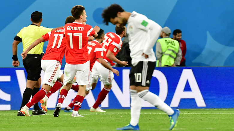 Egypt's forward Mohamed Salah reacts as Russia's forward Artem Dzyuba celebrates with teammates after scoring during the 2018 World Cup Group A football match between Russia and Egypt at the Saint Petersburg Stadium in Saint Petersburg, Russia on June 19, 2018. (Photo: AFP/Giuseppe Cacace)