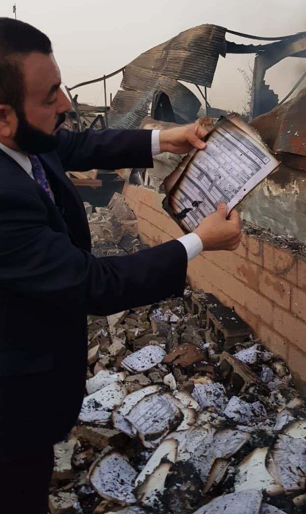 عادل نوری عضو پارلمان عراق در حال مشاهده کردن برگه‌های سوخته انتخابات پارلمانی عراق در منطقه الرصافه بغداد در روز 20 خرداد 97