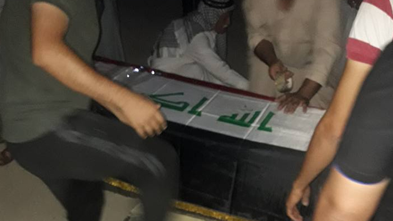 احد الضحايا تم لفه بالعلم الوطني بعد مقتله في هجوم داعش