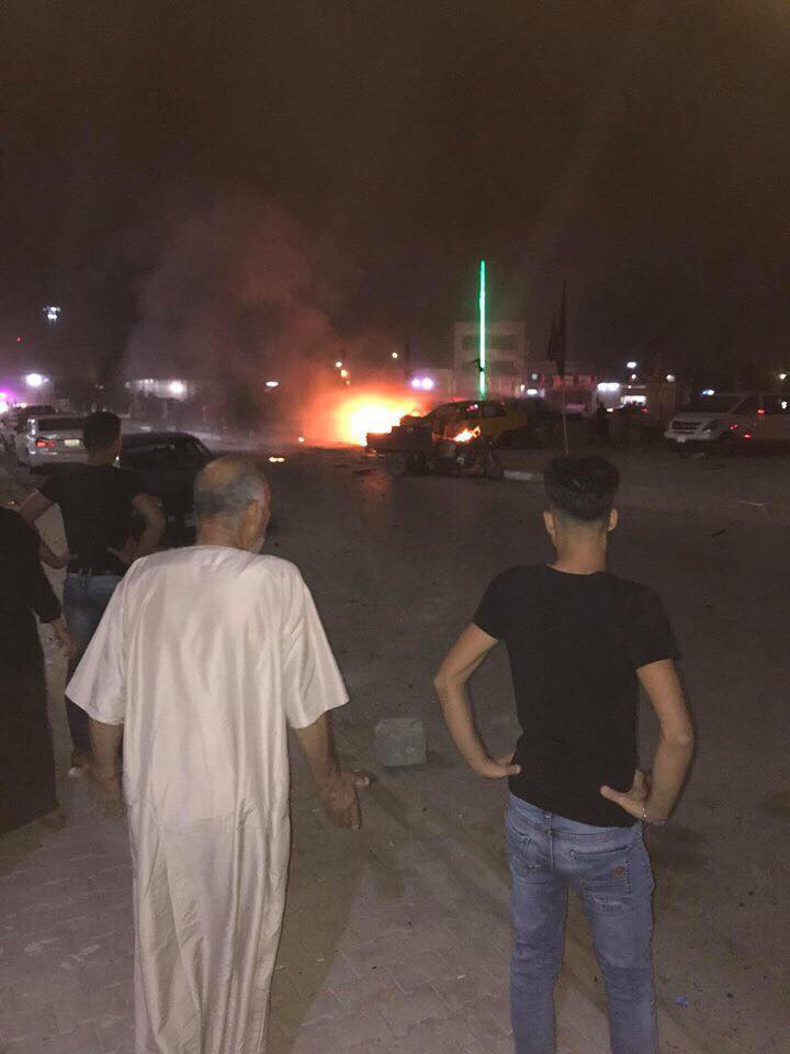 People stand close to the scene of a car bomb explosion in Kirkuk on Sept. 19, 2018. (Photo: Social media)