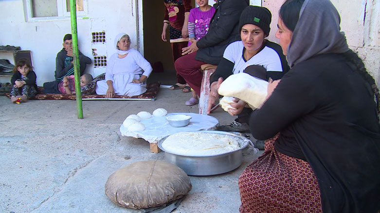 Some members of the Ezidi families sit in an unfinished building in Erbil and prepare to bake local traditional bread, Oct. 30, 2018. (Photo: Kurdistan 24)
