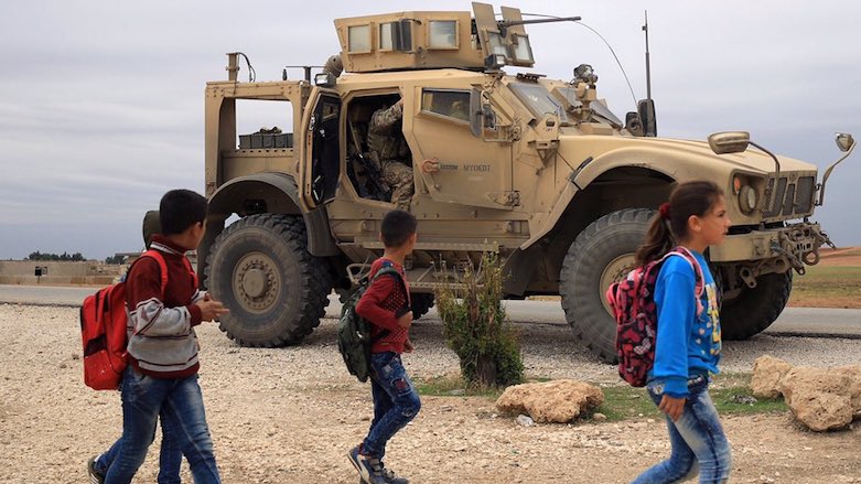 Children walk past an armored vehicle where American troops patrol near the Turkish border in Hasakah, Syria, Nov. 4, 2018. (Photo: Reuters/Rodi Said)