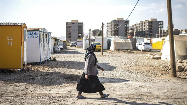 A woman walks past unfinished buildings nearly one year after the earthquake in Sarpol-e Zahab, Oct. 29, 2018. (Photo: Xinhua/Ahmad Halabisaz)