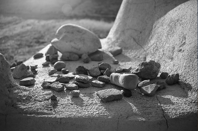 Prayer pebbles places at the altar at the base of the archaeological mound. (Photo: Levi Clancy) 