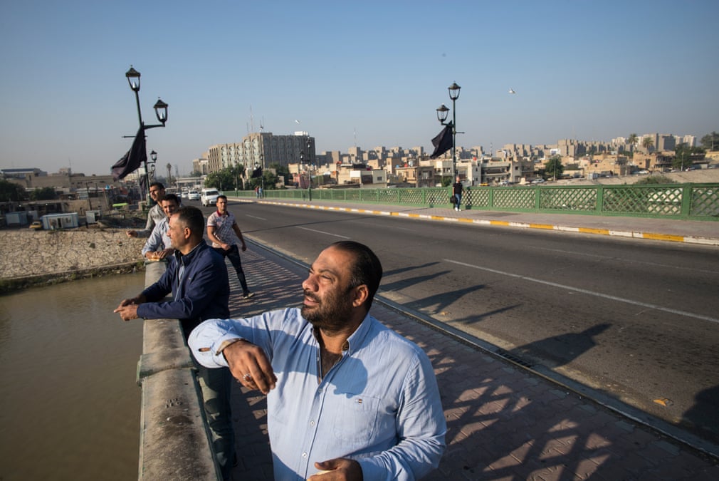 رجال يطعمون طيور النوارس من على جسر الاحرار قبل ذهابهم الى العمل (صورة: الغارديان)