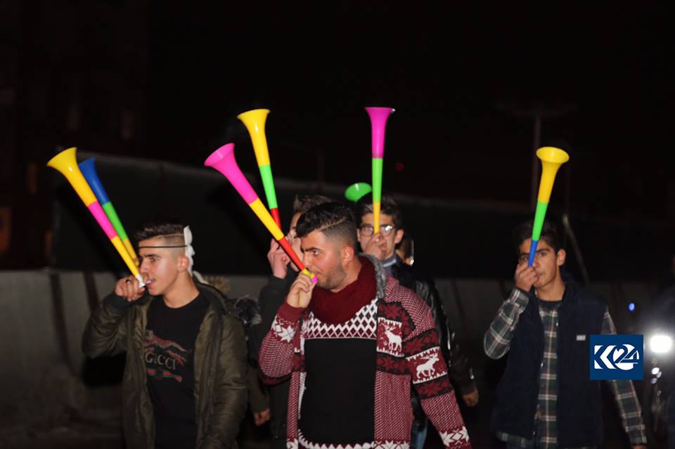 Youths in Sulaimani play air horns on New Year's eve.