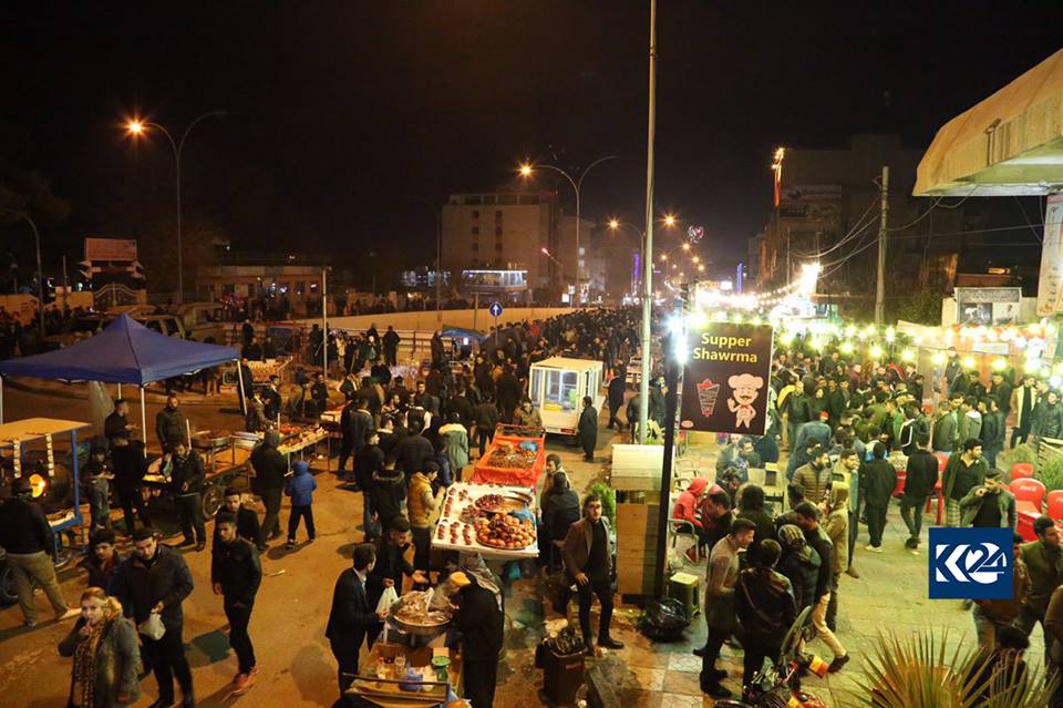 Sulaimani's Salim Street on New Year's eve flooded with locals some of whom paused at food stands for a snack.