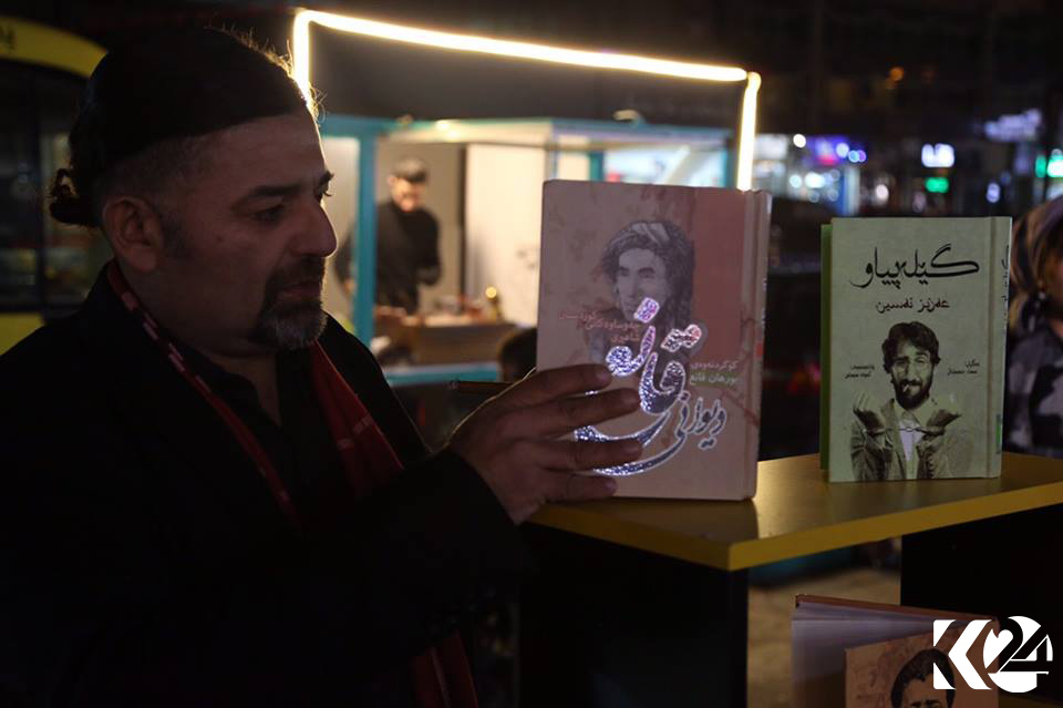 People walking down Salim Street’s sidewalk pause at a bookstore to check out some of the reads available.