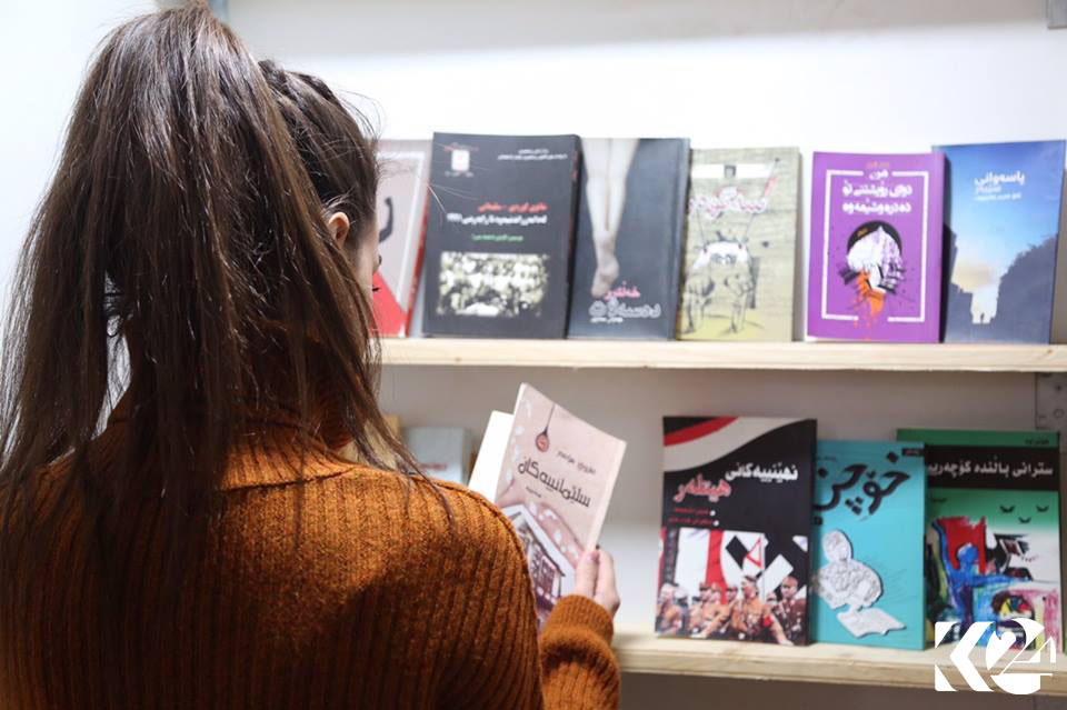 People walking down Salim Street’s sidewalk pause at a bookstore to check out some of the reads available.