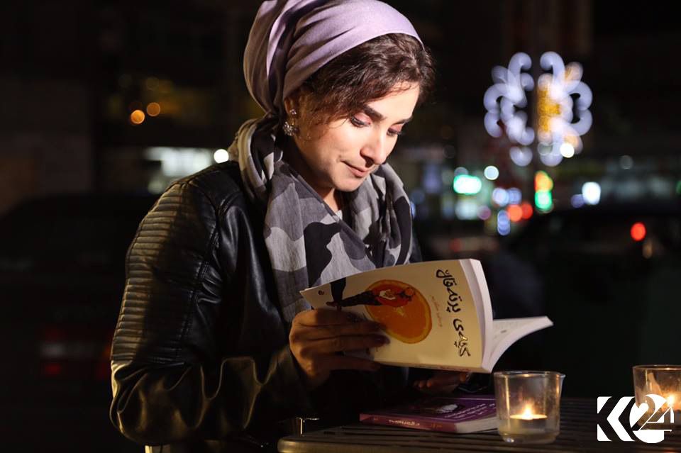People walking down Salim Street’s sidewalk pause at a bookstore to check out some of the reads available.