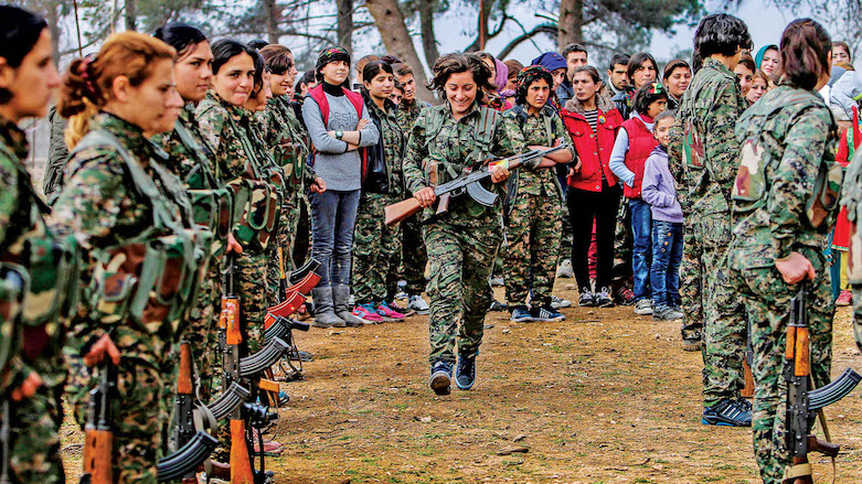 A fighter of the People’s Protection Units (YPG) in Syrian Kurdistan runs back to her place in formation after receiving her military card in January 2015. (Photo: Reuters)