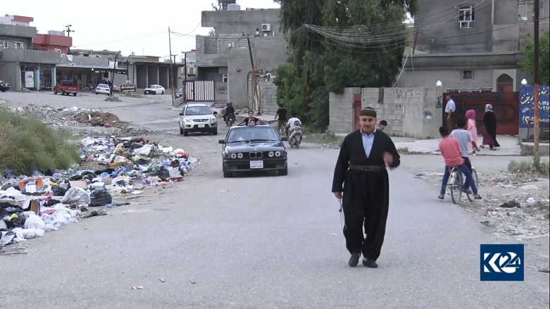Fayeq Qadir, a Kurdish resident in Kirkuk, walks in his neighborhood which has trash strewn next to the road, May 10, 2019. (Photo: Kurdistan 24)