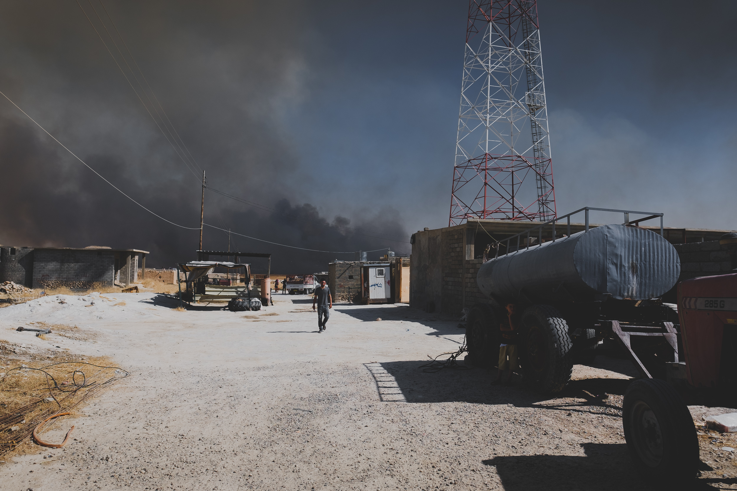 A family evacuates Wardia on Highway 47, south of Shingal Mountain, as fire reaches the village. (Photo: Kurdistan 24/Levi Clancy)