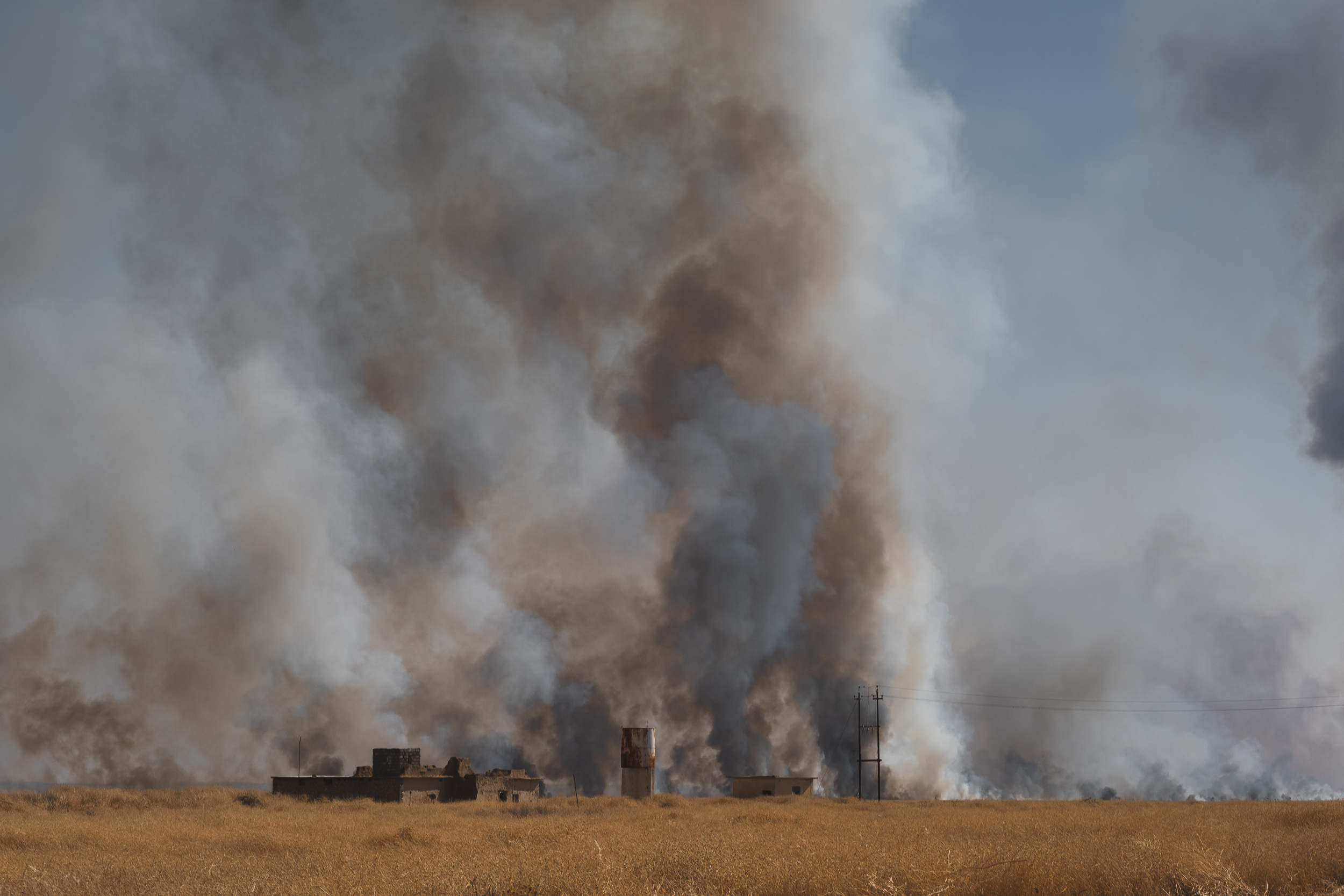 Flames overtake the Barakat Mahmoud Khero farm, six kilometers north of Tal Ezeer, the site of a massacre on Aug. 3, 2014. (Photo: Kurdistan 24/Levi Clancy)