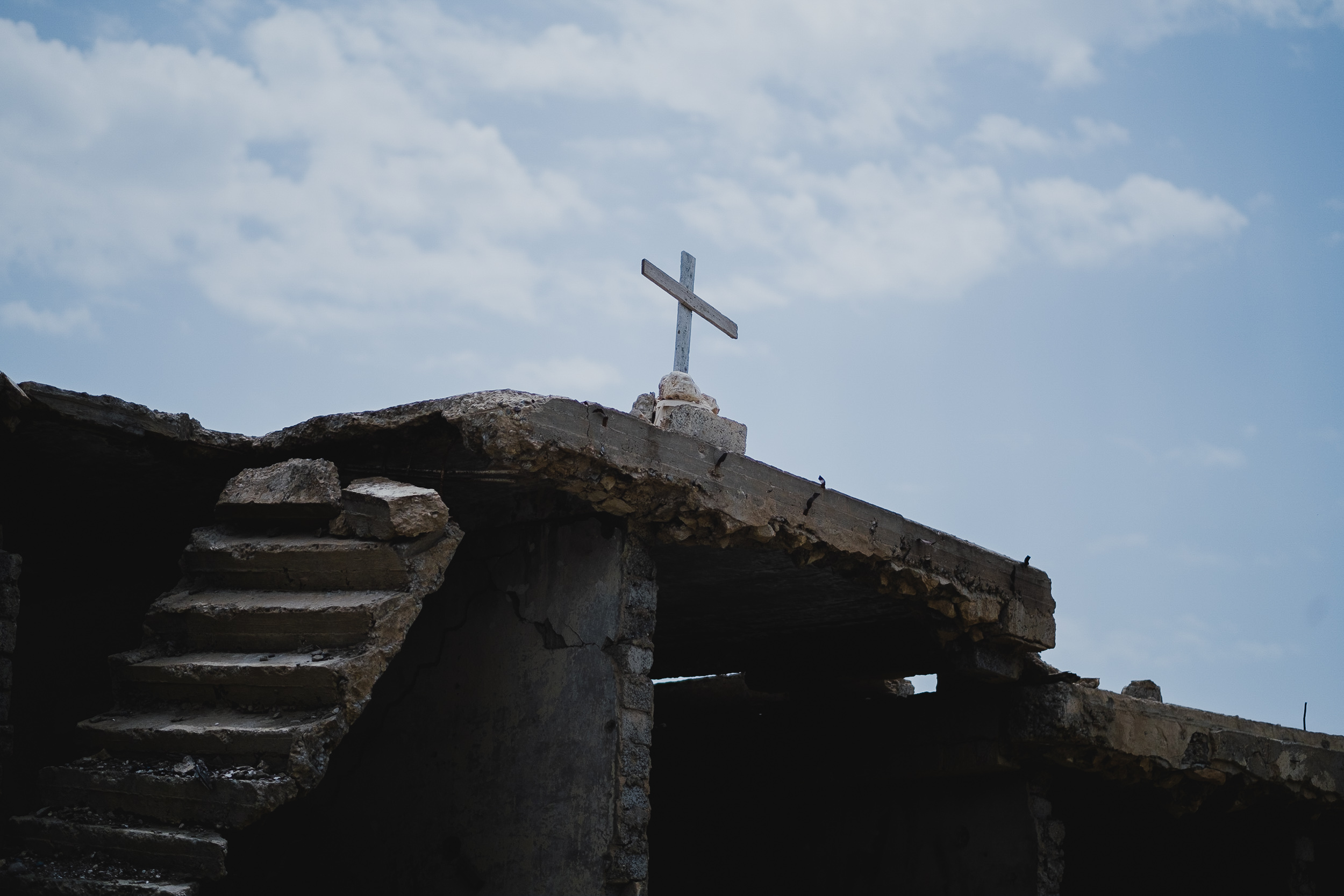Crucifix placed atop the rubble of the Syriac Orthodox church of the Virgin Mary. (Photo: Kurdistan 24/Levi Clancy)