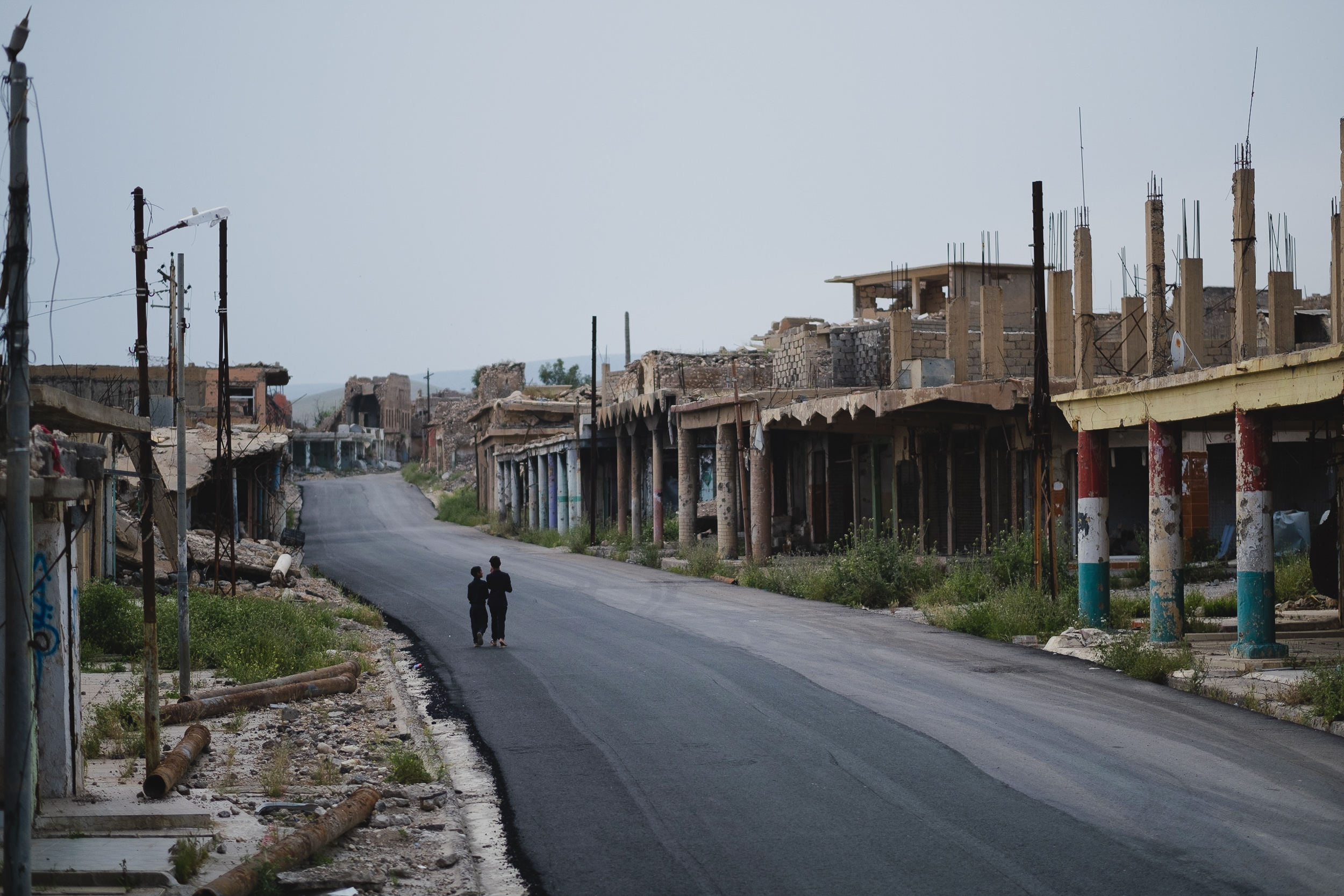 A view of ruins alongside a repaved section of an abandoned area in Shingal. (Photo: Kurdistan 24/Levi Clancy)